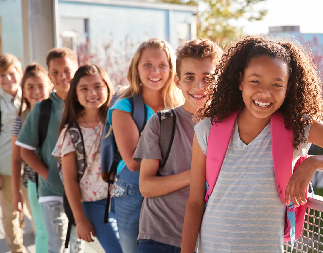 Students with backpacks lined up outside a school